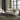 Elegant cream-colored sofa set with wooden frame and cushions, placed in a well-lit room with dark wood flooring and a round dark wood table in the foreground.