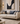 Beige sofa with decorative pillows in a stylish living room setting, featuring abstract art and modern decor.