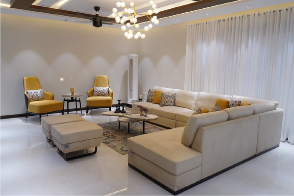 Modern living room with beige sectional sofa, yellow armchairs, and decorative pillows.