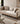 Beige sofa with wooden frame in a living room setting, featuring 'mohkam' branding.