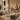 Modern living room with beige sofas, coffee table, and decorative elements in a showroom setting.