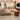 Modern living room with beige sofa, orange armchair, and television setup.