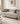 Beige sofa with decorative pillows in a stylish living room setting, featuring the brand 'Mohkam'.